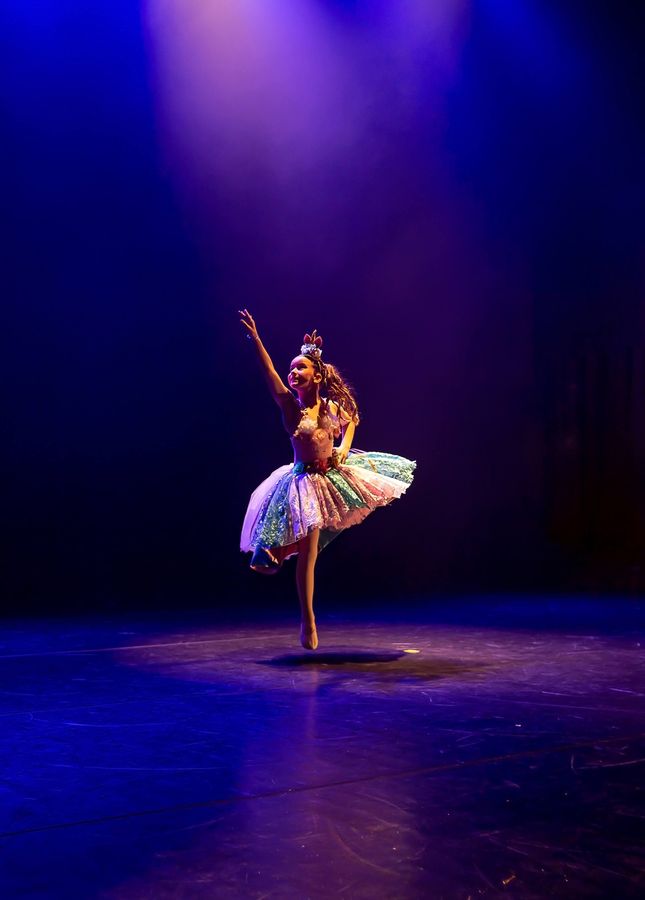 Bailarina sozinha no palco, na ponta, sob luz azul
