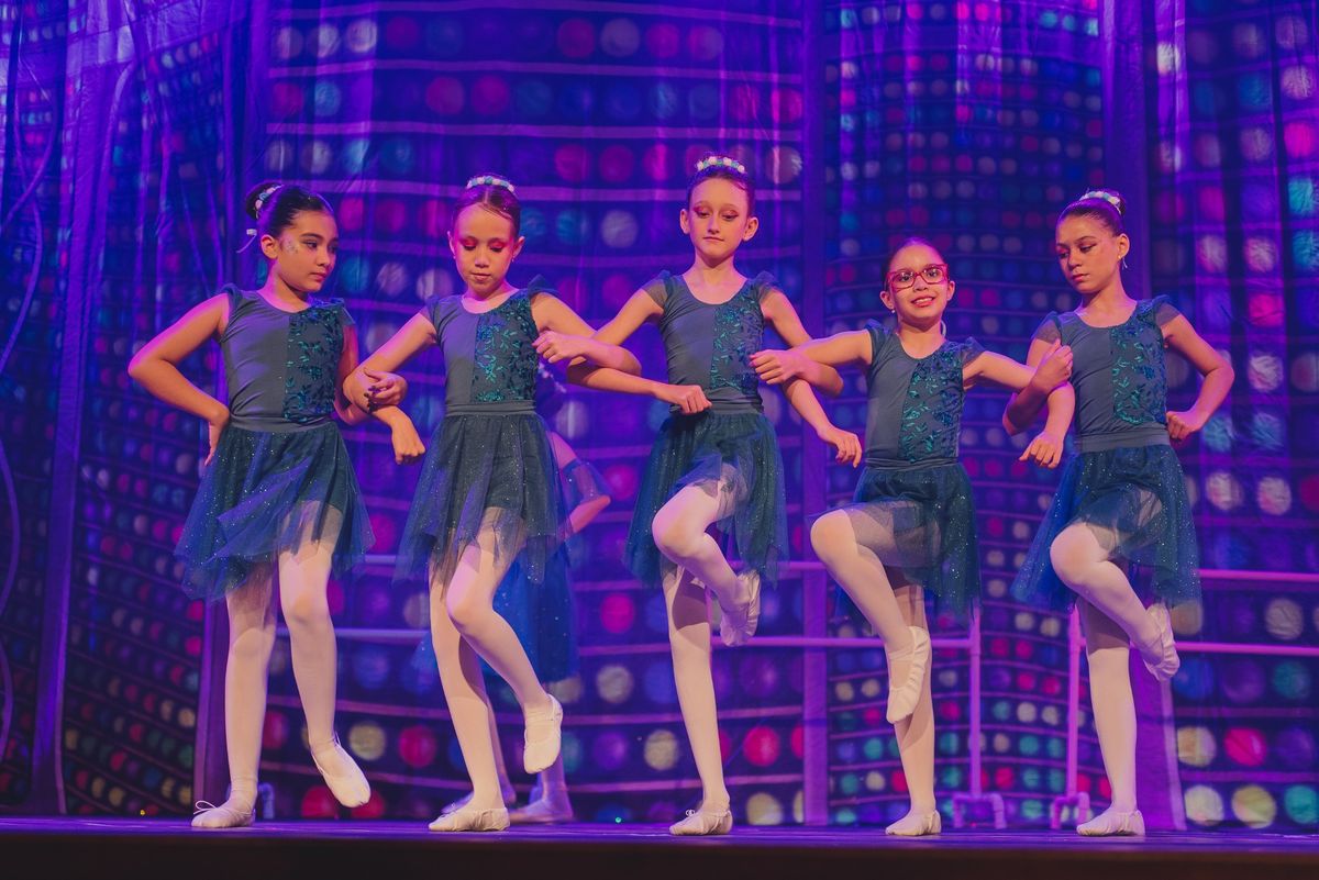 Cinco alunas do Jazz Infantil da Brilhart dançando no palco, de collant verde com saia de tule